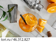 Glass of Aperol spritz cocktail and shaker on white background. Стоковое фото, фотограф Pixel_shot / Фотобанк Лори