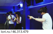 Portrait of happy excited young guy with VR glasses on head, holding handheld controllers playing virtual reality game with friends. Стоковое видео, видеограф Яков Филимонов / Фотобанк Лори