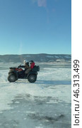 LAKE BAIKAL, OLKHON ISLAND, IRKUTSK REGION, RUSSIA -  February 22, 2025: Vertical video of couple of tourists traveling on ice of frozen Baikal Lake on ATV. People move on ATV on blue ice of Small Sea. Редакционное видео, видеограф Виктория Катьянова / Фотобанк Лори
