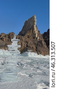 Vertical video of Baikal Lake in winter. High ice pyramids made of transparent ice floes against backdrop of famous Cape Khoboy - landmark of Olkhon Island.  Silhouettes of tourists in the distance. Стоковое видео, видеограф Виктория Катьянова / Фотобанк Лори