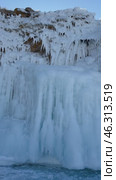 Vertical video  of Baikal Lake. View of icy rocks of Olkhon Island on cold day in February. Beautiful rocks with long icicles attract tourists and travelers. Winter adventures and outdoor activities. Стоковое видео, видеограф Виктория Катьянова / Фотобанк Лори