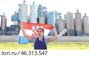 Sad young woman worker standing with big flag of Croatia against background of factory. Стоковое видео, видеограф Яков Филимонов / Фотобанк Лори