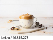 Glass cup of tasty dalgona coffee on white background. Стоковое фото, фотограф Pixel_shot / Фотобанк Лори