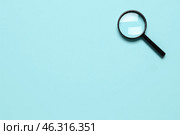 Black mini magnifier on blue background. Стоковое фото, фотограф Pixel_shot / Фотобанк Лори