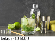 Glass of fresh mojito with shaker and jigger on grunge background. Стоковое фото, фотограф Pixel_shot / Фотобанк Лори
