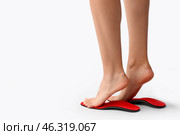 Female feet and red orthopedic insoles on light background. Стоковое фото, фотограф Pixel_shot / Фотобанк Лори