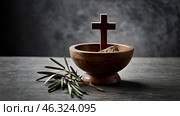 Religion, faith, liturgy, Ash Wednesday. Great lent. A wooden cross, a ceremonial bowl made of ash and an olive branch on a gray background. Стоковое AI-изображение, AI-художник Photojuli / Фотобанк Лори
