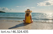 A beautiful little curly-haired girl in a straw hat and a yellow swimsuit on the beach by the sea. The concept of holidays with children, tourism and summer holidays by the water. Стоковое AI-изображение, AI-художник Photojuli / Фотобанк Лори