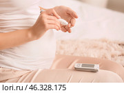 Pregnant diabetic woman taking blood sample with lancet pen at home. Стоковое фото, фотограф Pixel_shot / Фотобанк Лори
