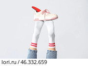 Sneakers with orthopedic insoles on female legs isolated on white background, closeup. Стоковое фото, фотограф Pixel_shot / Фотобанк Лори
