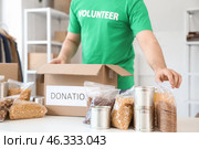 Male volunteer donating food in center, closeup. Стоковое фото, фотограф Pixel_shot / Фотобанк Лори