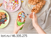 Woman eating sweet bubble waffle at table, top view. Стоковое фото, фотограф Pixel_shot / Фотобанк Лори