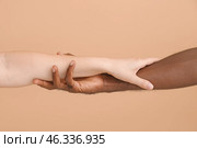 Caucasian woman and African-American man holding hands together on color background. Racism concept. Стоковое фото, фотограф Pixel_shot / Фотобанк Лори
