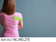 Woman with paper fish on her back against color background. April fools' day prank. Стоковое фото, фотограф Pixel_shot / Фотобанк Лори
