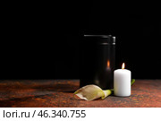 Mortuary urn, burning candle and flower on table against dark background. Стоковое фото, фотограф Pixel_shot / Фотобанк Лори