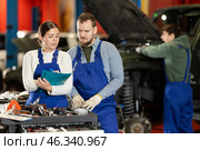 Car service manager discusses car repair problems with mechanic. He takes notes on paper. Стоковое фото, фотограф Яков Филимонов / Фотобанк Лори