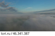 Flight from above over dense fog at dawn. Стоковое видео, видеограф Михаил Коханчиков / Фотобанк Лори