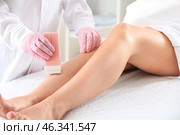 Beautician epilating legs of young woman in salon. Стоковое фото, фотограф Pixel_shot / Фотобанк Лори