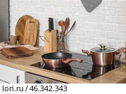Wooden kitchen counter with cutting boards, electric stove and utensils. Стоковое фото, фотограф Pixel_shot / Фотобанк Лори