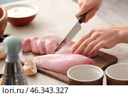 Woman cutting chicken fillet in kitchen, closeup. Стоковое фото, фотограф Pixel_shot / Фотобанк Лори