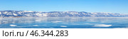 Winter Baikal Lake. Panorama of frozen Small Sea with beautiful blue clear ice surface and mountain range in distance on sunny frosty February day. Natural background. Scenic landscape. Panoramic view. Стоковое фото, фотограф Виктория Катьянова / Фотобанк Лори