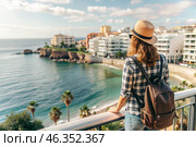 A girl traveler with a backpack on the background of the southern coast of the sea. A woman travels, enjoys life and the environment. Tourism. Стоковое AI-изображение, AI-художник Photojuli / Фотобанк Лори