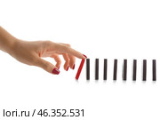 Female hand pushing dominoes on white background. Стоковое фото, фотограф Pixel_shot / Фотобанк Лори