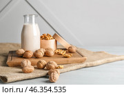 Bottle of milk with tasty walnuts on table. Стоковое фото, фотограф Pixel_shot / Фотобанк Лори