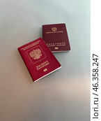 Russian and Colombian biometric passports placed on a surface. Стоковое фото, фотограф Виктор Ветошкин / Фотобанк Лори