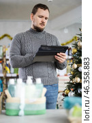 Male businessperson with tablet, plans to replenish restock stores inventory on Christmas Eve. Стоковое фото, фотограф Яков Филимонов / Фотобанк Лори