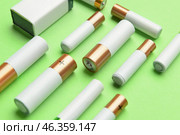 Different alkaline batteries on green background. Стоковое фото, фотограф Pixel_shot / Фотобанк Лори
