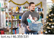 Man buyer with filled basket household chemistry wanders around store. Стоковое фото, фотограф Яков Филимонов / Фотобанк Лори