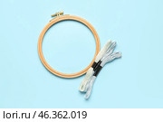 Wooden embroidery hoop with mouline threads on blue background. Стоковое фото, фотограф Pixel_shot / Фотобанк Лори