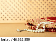 Muslim prayer mat and beads on color background. Стоковое фото, фотограф Pixel_shot / Фотобанк Лори