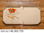 Pizza box with leftovers on wooden background. Стоковое фото, фотограф Pixel_shot / Фотобанк Лори