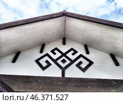 Intricate traditional design on a building eave against a blue sky with clouds. Стоковое фото, фотограф Кривошеина Елена Леонидовна / Фотобанк Лори