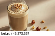Mockup. Hot hazelnut coffee on a pale beige background. Space for text. Spice Latte or cappuccino. A rich and creamy hazelnut latte with a crumb of crushed nuts, served in a clear glass. Стоковое AI-видео, аниматор Марина Демидюк / Фотобанк Лори