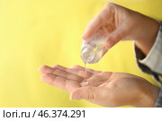 Woman using antibacterial hand gel on color background, closeup. Стоковое фото, фотограф Pixel_shot / Фотобанк Лори