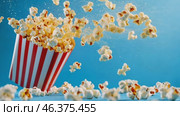 Red white stripe box of popcorn. Popcorn floating out of the paper box, isolated on a light blue background. Striped retro bucket with freshly popped popcorn with some pieces flying. Snack food. Стоковое AI-видео, аниматор Марина Демидюк / Фотобанк Лори