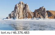 Video of winter Baikal Lake. View of famous Shamanka Rock or Cape Burkhan - natural landmark of Olkhon Island. Scenic winter landscape with blue ice on sunny day in February. Travels and recreation. Стоковое видео, видеограф Виктория Катьянова / Фотобанк Лори