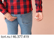 Young man with hemorrhoidal suppository on color background. Стоковое фото, фотограф Pixel_shot / Фотобанк Лори
