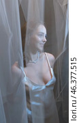 Slow motion vertical video of young female covered with veil. Woman is dressed in a peignoir and wears a necklace and earrings. Стоковое видео, видеограф Сергей Пристяжнюк (Serg Zastavkin) / Фотобанк Лори