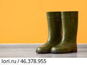 Pair of gumboots on floor against color wall. Стоковое фото, фотограф Pixel_shot / Фотобанк Лори