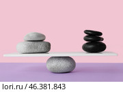 Spa stones on teeterboard against pink background. Concept of balance. Стоковое фото, фотограф Pixel_shot / Фотобанк Лори