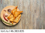 Plate with tasty Uzbek samsa and spices on wooden background. Стоковое фото, фотограф Pixel_shot / Фотобанк Лори
