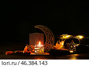Arabic candle holder with glowing candle, garland and tasbih on dark background. Стоковое фото, фотограф Pixel_shot / Фотобанк Лори