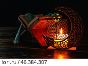 Arabic candle holder with glowing candle, Quran and tasbih on dark background. Стоковое фото, фотограф Pixel_shot / Фотобанк Лори