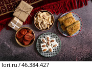 Tasty Eastern sweets with gifts on dark background. Стоковое фото, фотограф Pixel_shot / Фотобанк Лори