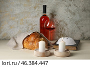 Glowing candles with traditional challah bread, wine, Torah and Jewish cap on grunge background. Shabbat Shalom. Стоковое фото, фотограф Pixel_shot / Фотобанк Лори