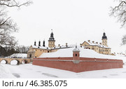 Winter landscape with a historic castle and bridge covered in snow. Nesvizh (2024 год). Стоковое фото, фотограф EugeneSergeev / Фотобанк Лори